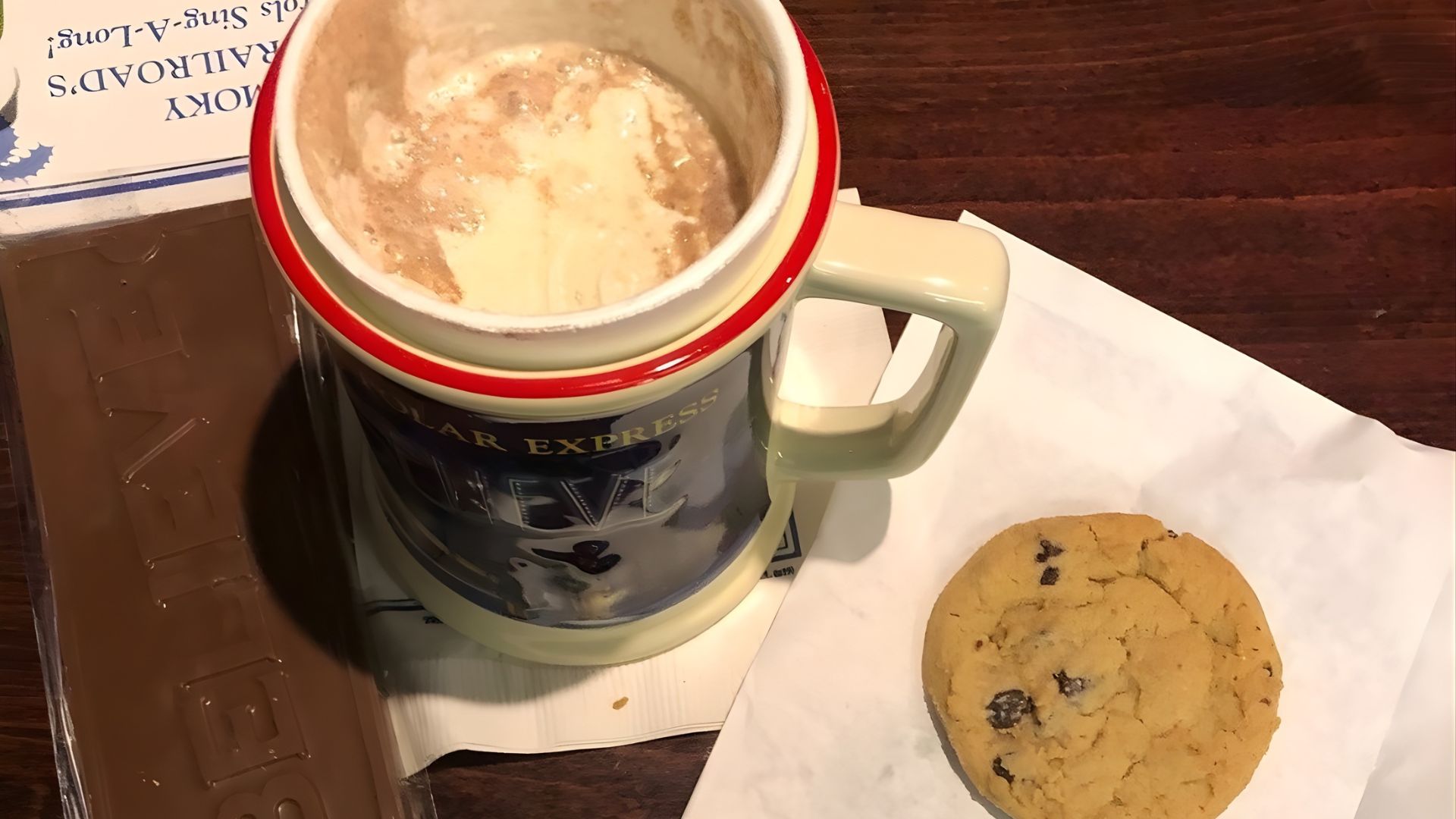 Chocolate in a mug, bar of chocolate, and a cookie.