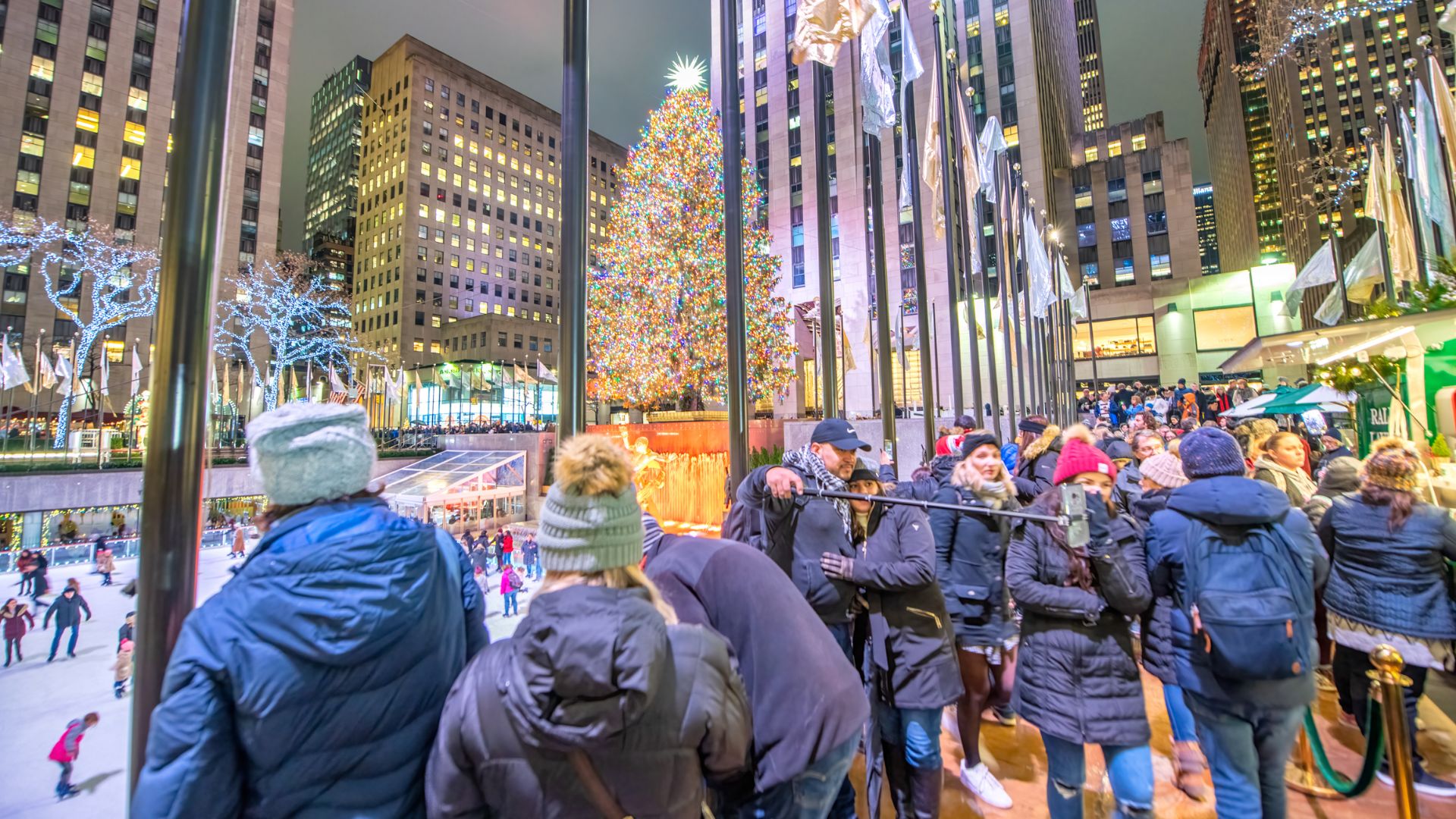 Iconic Christmas tree in Rockefeller Center in New York City, USA with a lot of people.