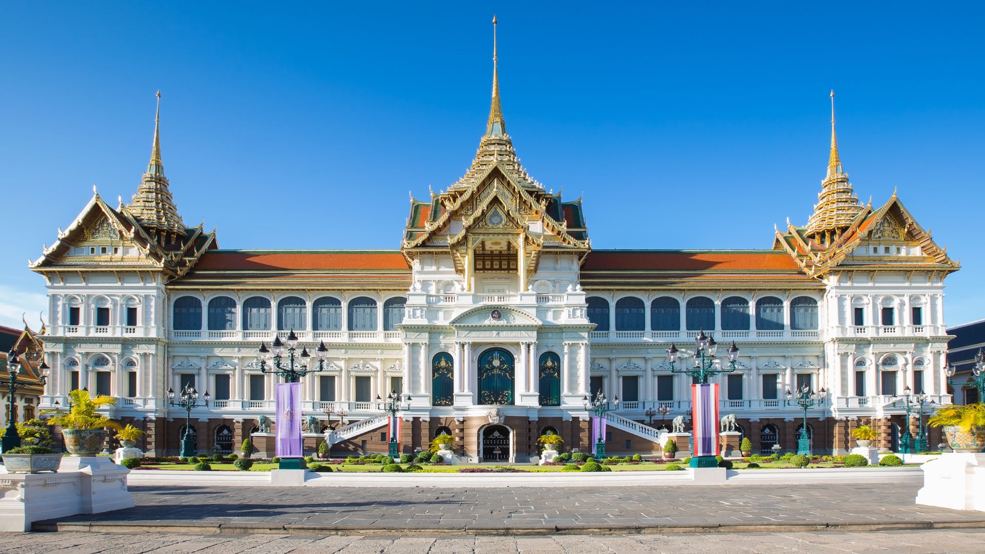 A large, ornate 19th-century palace building featuring a blend of Italian Renaissance architecture at the base and a traditional Thai-style, multi-tiered roof with spires.